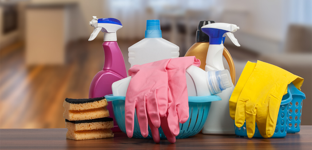 cleaning supplies sitting on a table with new home in the background